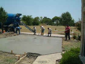 Pouring and floating concrete for the driveway expansion.